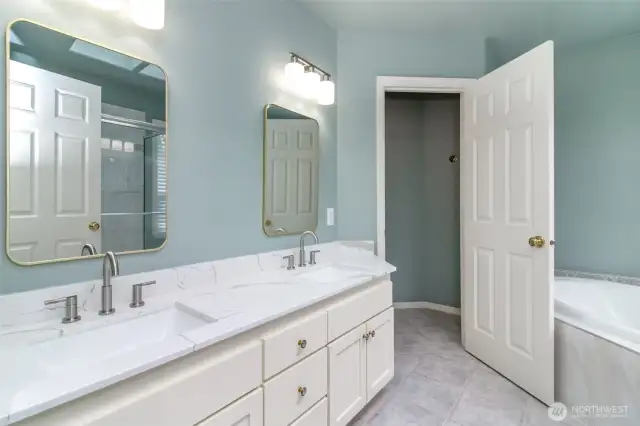Admire the stunning quartz countertops, brand new sink, updated mirrors, modern plumbing fixtures, and elegant lighting. Indulge in the comfort of your private soaking tub, with a separate enclosed area for the toilet ensuring added privacy.