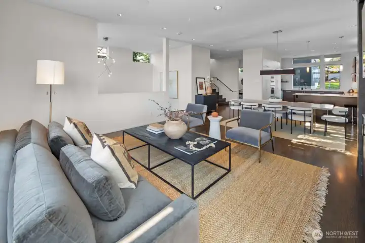 Living room looking back across the dining space towards the sunken entry and staircase to the bedroom level