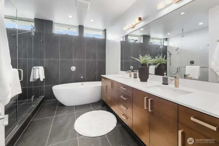Primary suite bathroom, featuring a massive Victoria + Albert soaking tub and walnut vanity