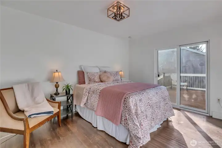 Main-level bedroom with sliding glass door leading to the back deck. Main-level bedroom with sliding glass door leading to the back deck.