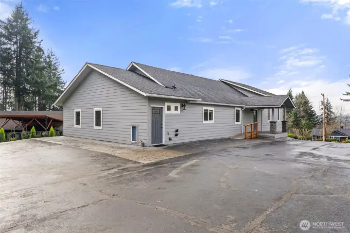 Home with stamped concrete patio and black top paved driveway.