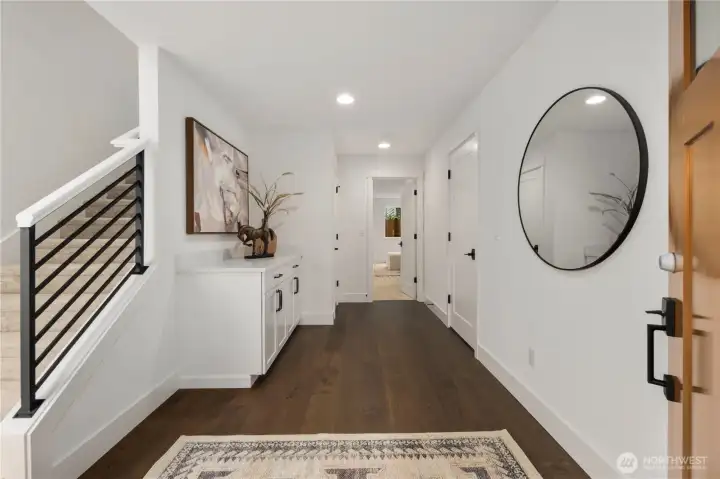 Entry Foyer: Inviting entry foyer with hardwood-style floors, fresh white millwork, and built-in storage cabinetry. The thoughtful design sets the stage for the home’s modern style while connecting seamlessly to the lower-level suite and garage.    Photos are from the model home at Foxmoore and for visualization purposes only. Plans, colors, building orientation, finishes, home outlook, and other details can and WILL vary.