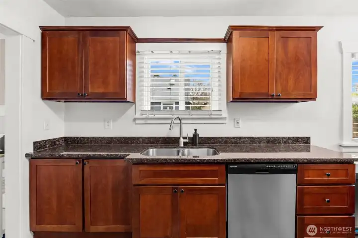 Kitchen with Rich Wood Cabinetry, Granite Counters, and Stainless Dishwasher