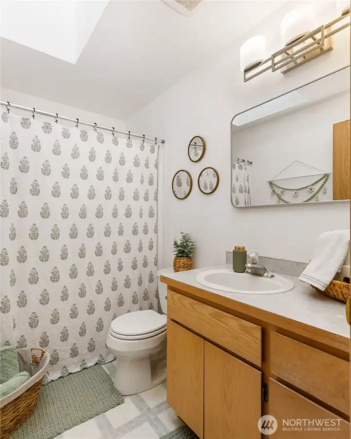 The guest bathroom has a full bath with skylight to let the Pacific North West sunshine in giving you great lighting. The vanity has deep drawers and under cabinet space.