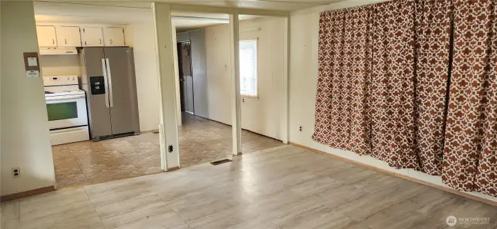 Looking from the living room, you can see there is also space for your dining table and chairs in the kitchen. The large windows to the right are covered with insulation behind the curtains.