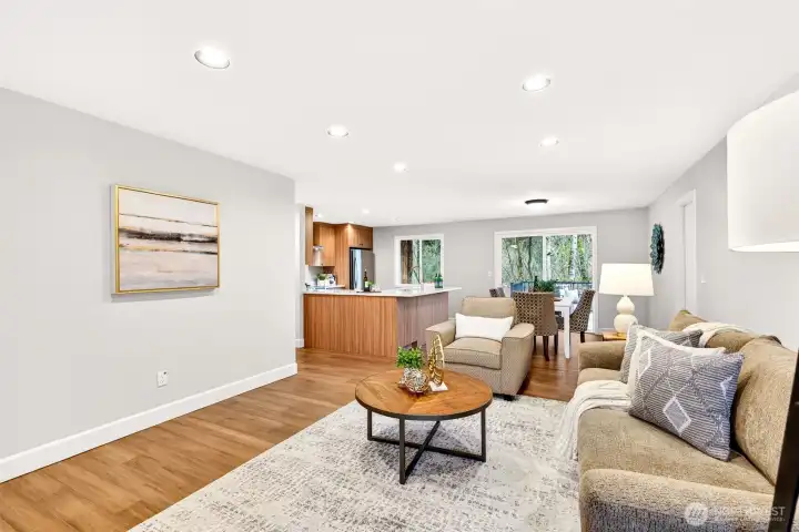 The great room's open sightline to the fully updated 2026 kitchen makes this the true heart of the home, ideal for hosting or simply enjoying daily life with everything within reach. Custom walnut-tone cabinetry, quartz countertops, and a stainless appliance suite are visible from every angle of this connected living space.