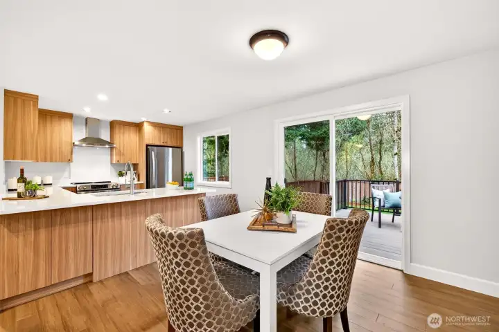 The 2026 kitchen remodel delivers a chef-worthy workspace with custom cabinetry, quartz counters, a new range, and stainless appliances — all oriented toward the wooded greenbelt view through the rear window and sliding door. Everyday meals gain an effortless quality when your kitchen opens directly to a private deck and mature tree canopy.