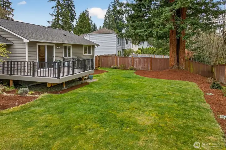 A fully fenced, level backyard with fresh landscaping and a mature greenbelt tree line along the rear fence creates a private outdoor environment that's rare to find in established Redmond neighborhoods. No HOA means you use this space exactly as you choose.