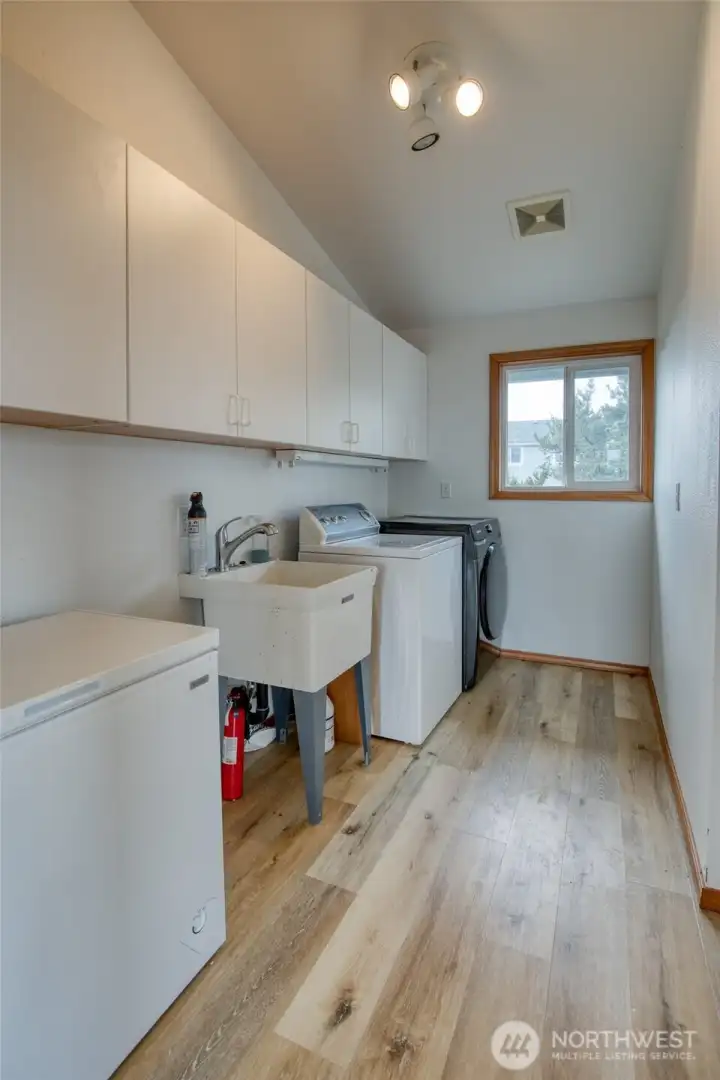 Laundry room with sink and chest freezer.