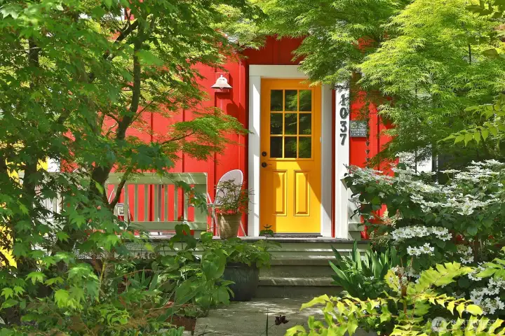A storybook approach framed by lush landscaping.