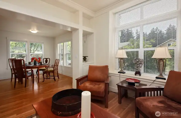 High ceilings give the living room an expansive feel. Original wood flooring enhances the home’s character.