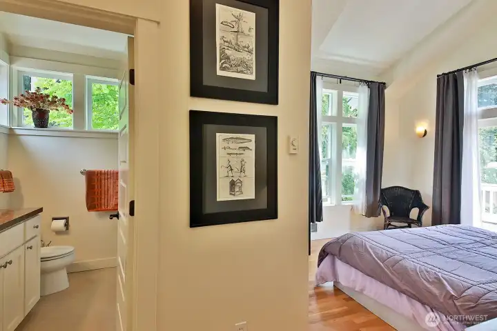 The primary bedroom with a vaulted ceiling is a calming retreat designed for rest and relaxation. A private balcony  extends the primary suite outdoors.