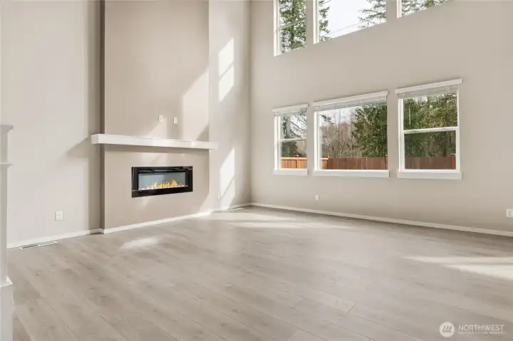 Bright and airy great room featuring a modern linear electric fireplace. Photos are representative only and may display different color package and/or upgrades.