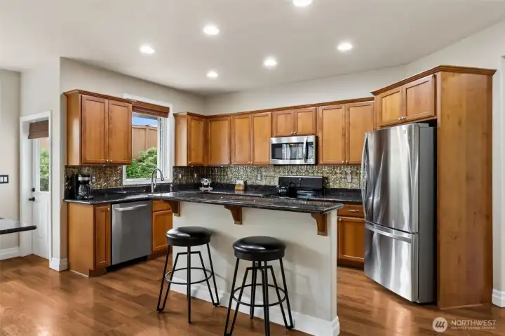 Large stainless steel deep sink, granite  countertops, attractive tin backsplash all  make this kitchen perfect for cooking.