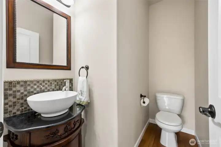 Nice powder room with custom vanity, raised bowl sink & decorative tile backsplash.