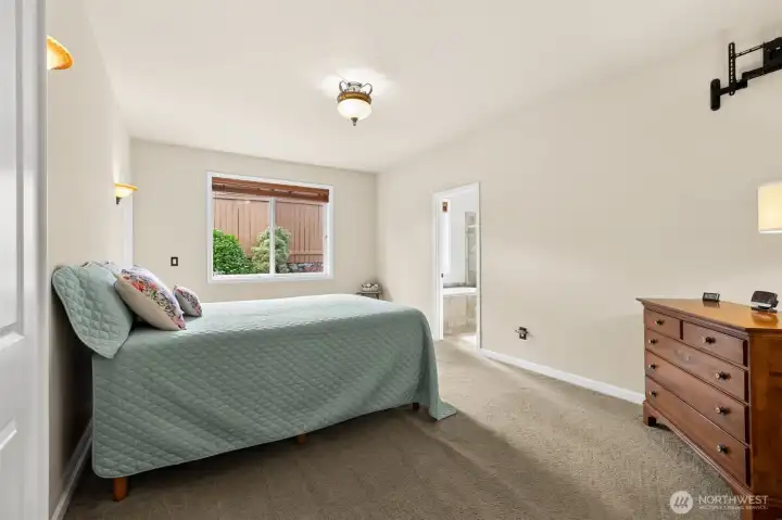 The primary suite boast several warm and comforting features - custom lighting, wall scone lighting, attached 5 piece bathroom, walk-in closet + exterior door to private backyard patio.