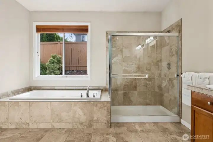 Primary suite bathroom boast an oversized soaking tub and full tile walk-in shower.