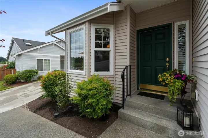 Covered font porch with driveway to private garage on the left.