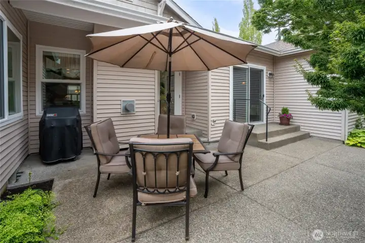 Patio embraced by lush landscaping allows for multiple seating areas & plenty of room for plants.