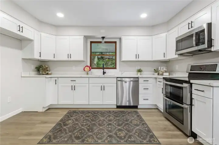 beautifully updated kitchen features a double oven, new microwave and new dishwasher.