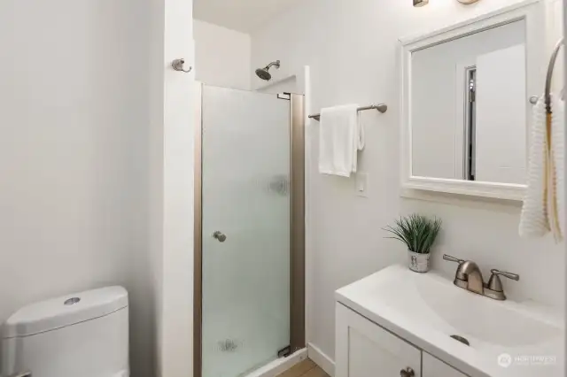 Welcome to the bright and simple upstairs bathroom. Painted in a light, refreshing color, this space features a convenient walk-in shower and updated fixtures. While not luxurious, it offers practicality and modern comfort for your daily routine.