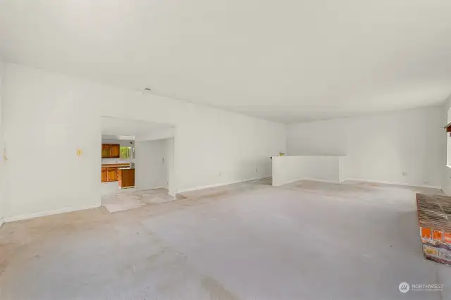 Upstairs living room off kitchen showing stairs down to bonus room.