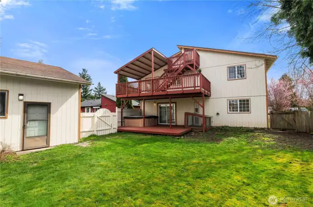 Multi level deck overlooking spacious fenced backyard.