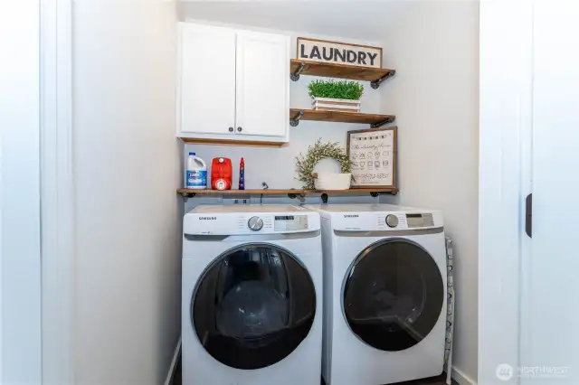 Full sized washer and dryer in cute laundry room with french doors