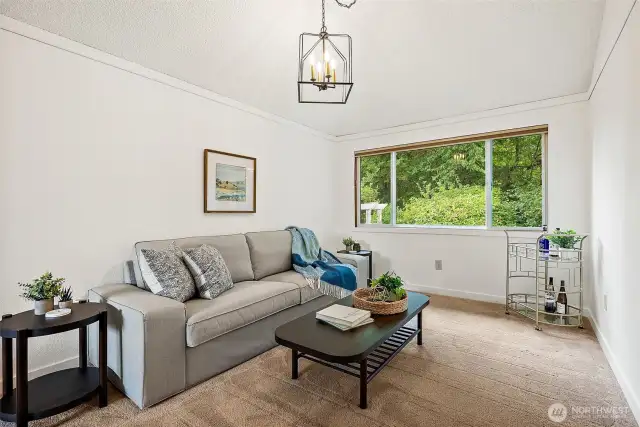 The formal dining room, used here as a lounge area, also has a large window with views of the backyard.