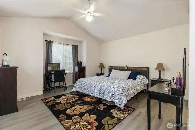 Spacious primary bedroom with vaulted ceilings.