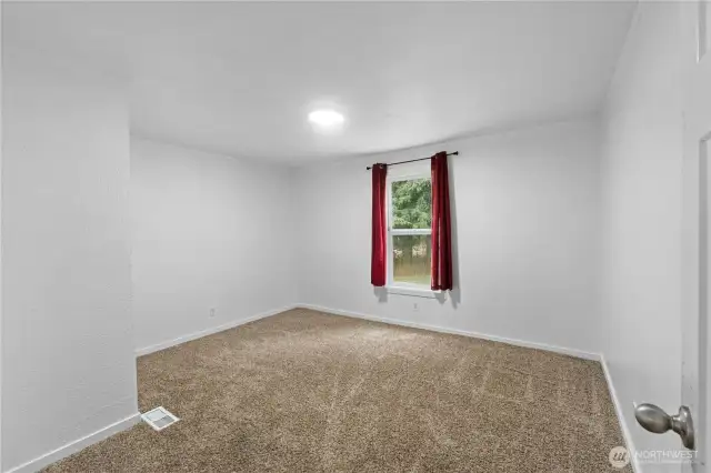 Front bedroom off the living room, could be the primary with split bedroom floor plan, or could be an office/den or family room as well.