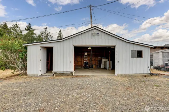 Garage with doors open. The small door at the left opens to shelves for storage space.