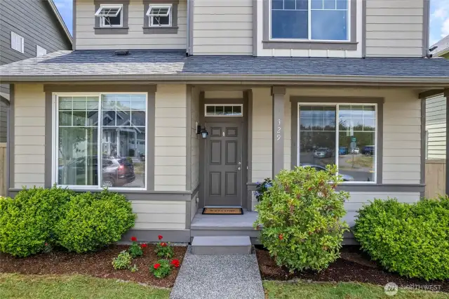 AS one approaches the front door, there's a covered outdoor deck, another place to relax with outdoor chairs in place.