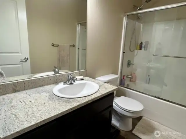 Upstairs hall bathroom with a granite countertop