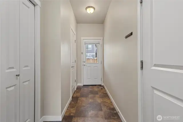 Hallway from kitchen to half bath, garage, guest closet and door to back patio.