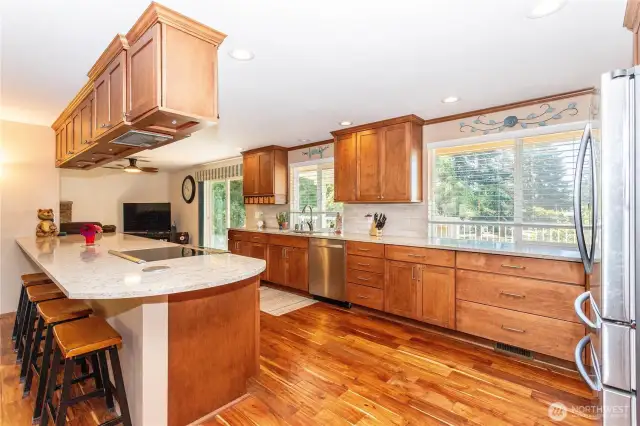 The kitchen is a true centerpiece, offering a massive island with bar seating and an abundance of workspace. Granite-style counters and custom wood cabinetry give the room a warm yet polished look. Stainless steel appliances add a modern touch, while the open design ensures the kitchen connects effortlessly to the living and dining spaces. This is a dream kitchen for home chefs and entertainers alike, offering both functionality and style.