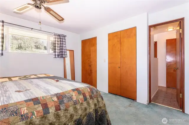 From this angle, you see the generous storage with dual closets and convenient access to the hallway. Natural light continues to brighten the space, and the layout shows how practical and functional this bedroom is. The room is well-proportioned, making it easy to design around, whether you prefer a minimalist look or a fully furnished retreat. It’s a versatile owner’s suite with potential to modernize to your taste.