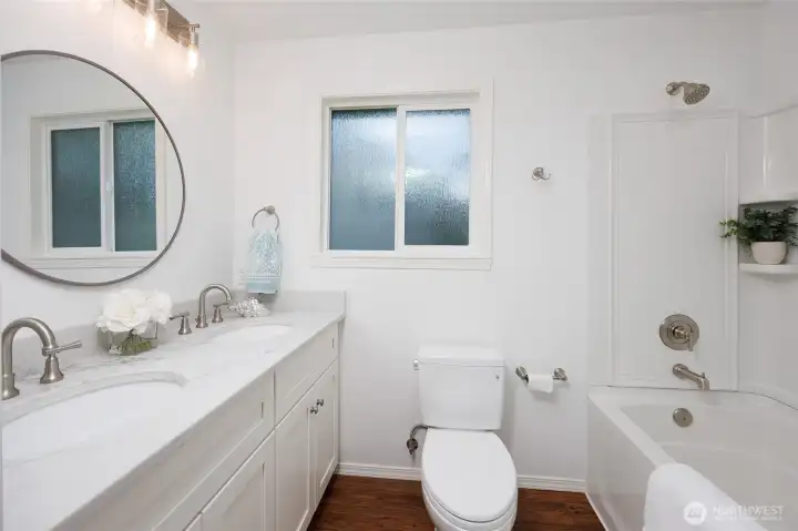Full hall bathroom with dual vanity.