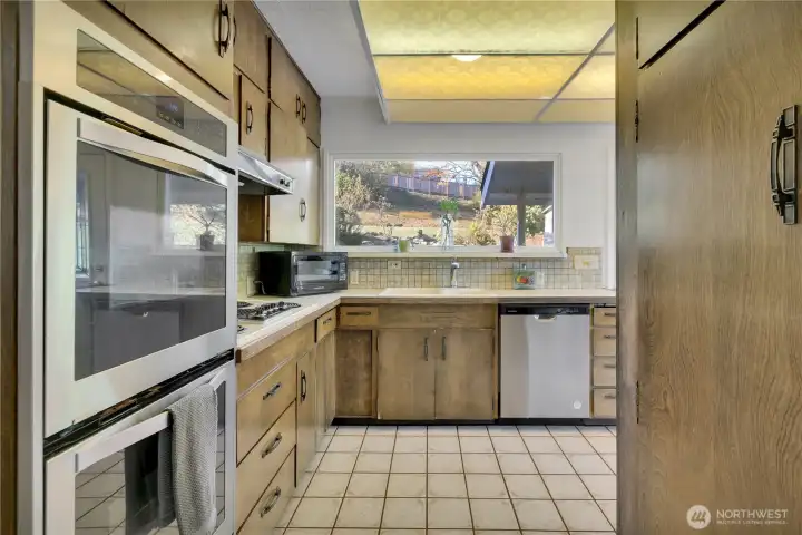 Retro kitchen w/double ovens, tile backsplash & view window above sink.