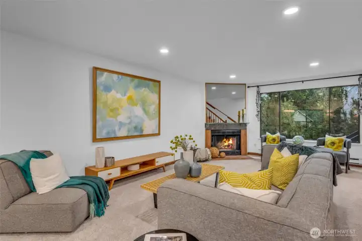 The living room lives large.  Can lighting, big picture window lots tons of light in and the wood burning fireplace ties the space together.