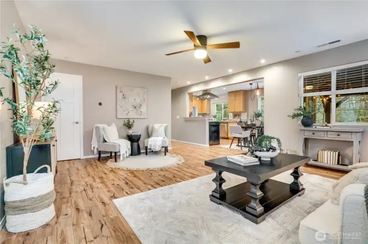 Open living, dining and kitchen. Notice how the windows overlook the backyard. Mature Garry Oak trees and diverse PNW foliage.
