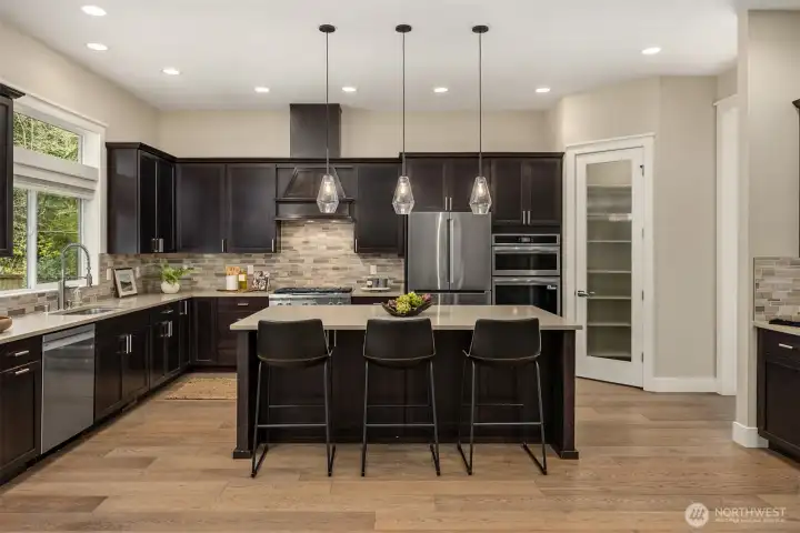 Gourmet kitchen with island seating, pendant lighting, walk-in pantry, and high-end finishes—modern design meets practical living on Bainbridge Island.