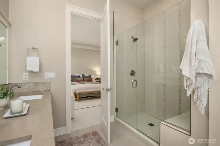 Primary bath glass-enclosed shower with seat shelf and clean, modern finishes.