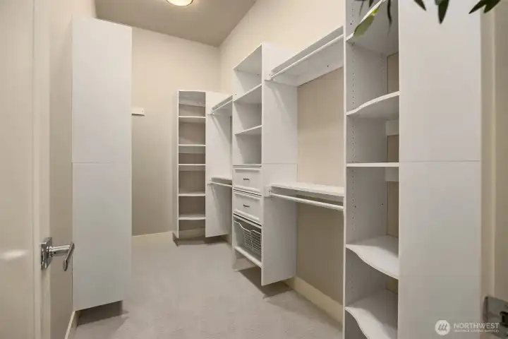 Custom walk-in closet with built-in shelving, drawers, and abundant hanging space for effortless organization.