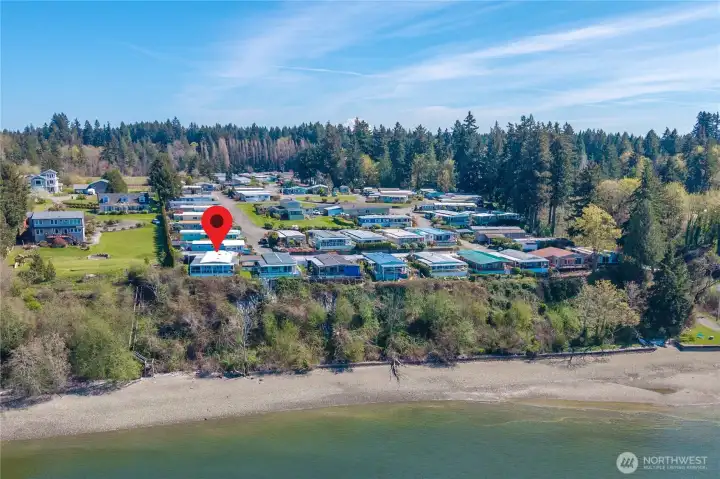Aerial perspective captures the home’s rare, private positioning along the bluff with easy access to the beach below through the walking trail on the right side near the trees.