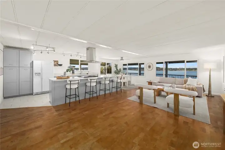 Step inside to a light-filled open-concept layout with warm cork flooring, designed for gathering, entertaining, and enjoying the view from every main living space.