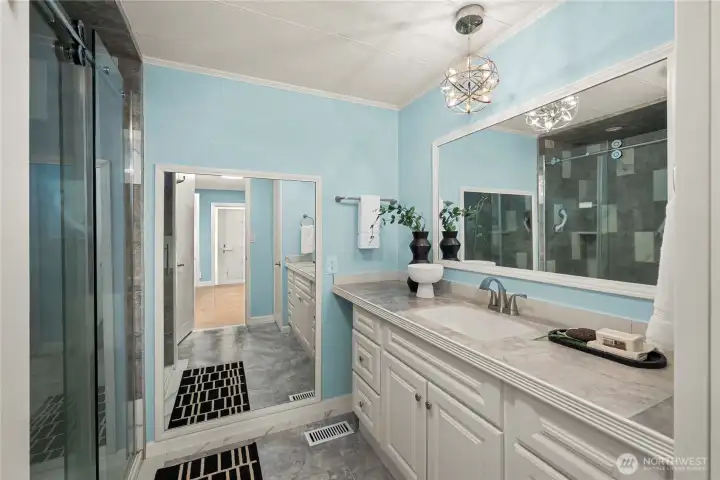 The updated primary bathroom features an extended vanity with ample counter space and storage for a clean, polished feel.