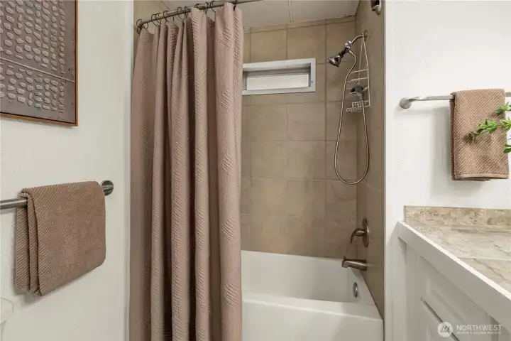 The guest bathroom features clean finishes and a full tub/shower combination, offering a fresh and functional space for everyday use.