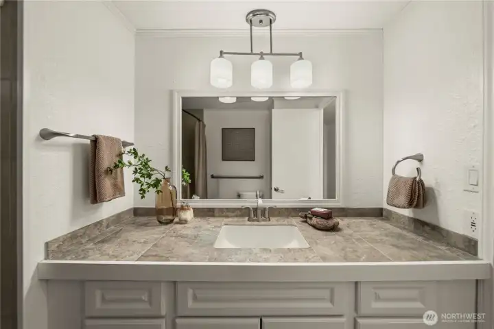 A spacious vanity with generous counter space and storage enhances the bathroom with a clean, refined look.