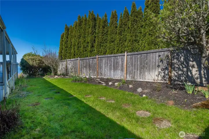 Fully fenced yard with water views offers a private outdoor space to relax, garden, or enjoy the coastal surroundings.